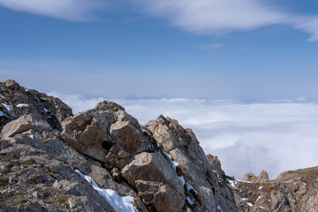 Dramatic high mountain landscape with snow, rocks and low clouds