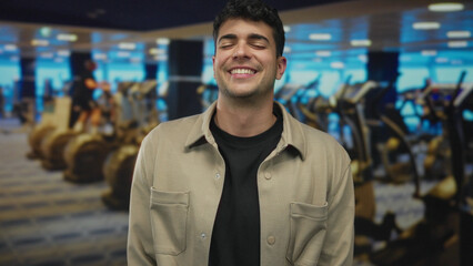 Naklejka premium Young hispanic man eyes closed smiling in gym; calm relief relaxation serenity.