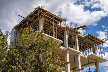 The frame of a building under construction. The structure of the building. Construction of load-bearing reinforced concrete columns at home. Construction technologies. Reinforcement of concrete.