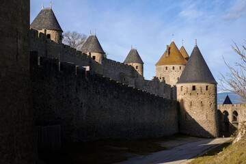 Impressive medieval castle wall with defensive towers and stone architecture, part of the historic fortified city of Carcassonne in southern France. © Diego