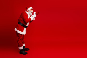 Festive Santa Claus with a megaphone in hand against a vibrant red background during the holiday season