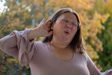 Woman covering ears with pained expression, Emotional portrait showing discomfort loud noise,...