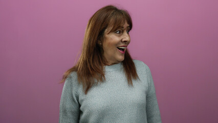 Fototapeta premium Woman senior smiling against pink background wearing sweater showcasing joyful expression and conveying happiness optimism and warmth in studio setting.