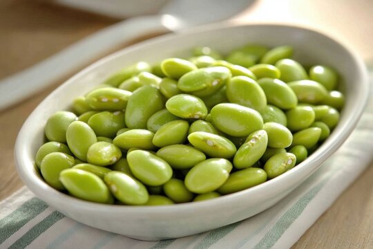 White oval-shaped bowl filled green edamame beans is Lima