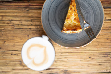 Latte Macchiato mit Latte Art Herz und Kuchen von oben