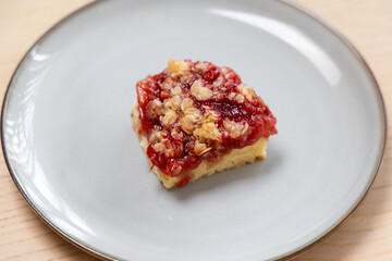 A slice of strawberry rhubarb cake with oat crunch.