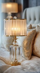 Elegant crystal lamp on a bed.  Soft lighting and luxurious fabrics