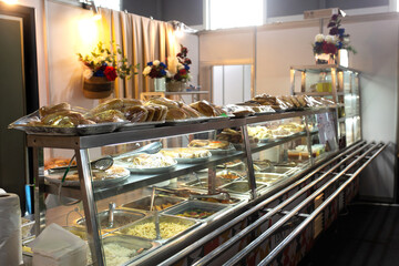 Long glass counter with bread, appetizers, and side dishes.