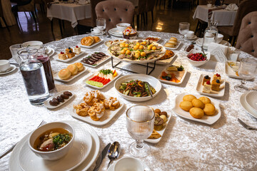 Top view of a lavish table with roasted meat, salads, desserts, and appetizers.