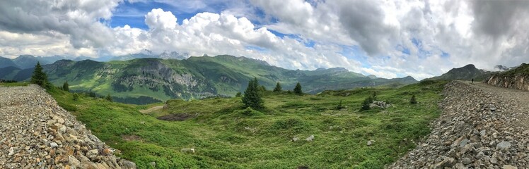 Naklejka premium Panoramic view of lush green mountains under a cloudy sky