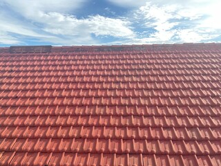 rustic roof or red roof tiles under a clear blue sky, house exterior shot from below on a sunny day