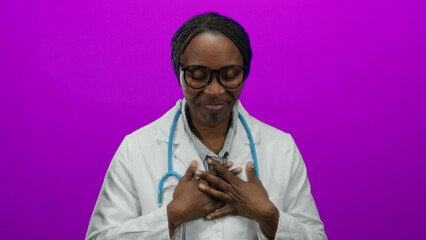 Smiling female doctor with stethoscope over pink background, emphasizing healthcare professionalism.