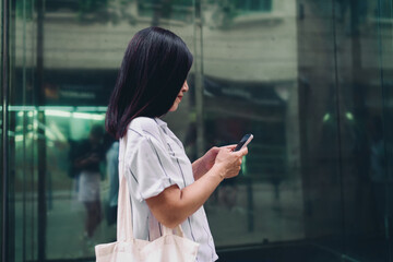Woman checking phone mid-walk, eyes focused on screen, illustrating real-time mobile interaction,...