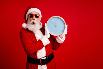 Santa Claus in festive attire holding a clock on a vibrant red backdrop emphasizing holiday celebration and joy