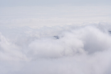 Misty mountain peak covered in snow, floating above dense clouds