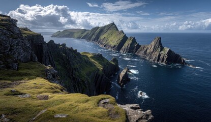 Dramatic coastal vista of jagged cliffs and emerald green hills meeting a dark ocean, with fluffy white clouds and a vibrant blue sky
