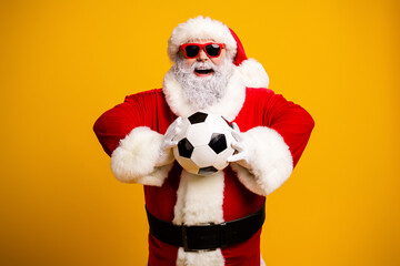 Santa Claus in festive attire happily holding a soccer ball, radiating holiday cheer, fun vibes, and Christmas spirit