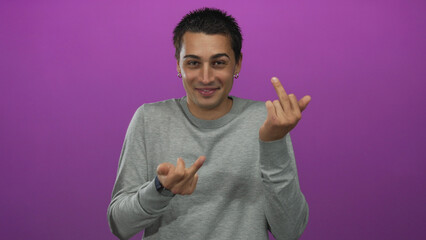 Young hispanic man flips middle finger at camera in purple studio; rebellion mischief defiance.