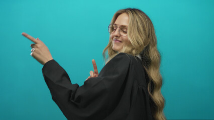 Young blonde woman in a judge uniform gestures confidently against an isolated green wall...