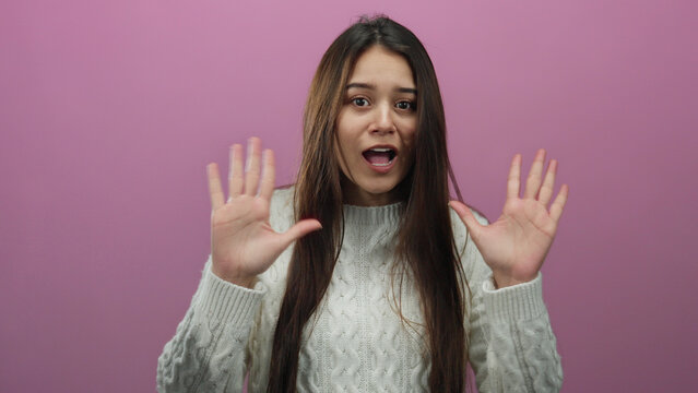 Woman gesturing on isolated pink background with long hair wearing sweater showing emotions with hands hispanic expressive facial expression adult discussion pointing vibrant.