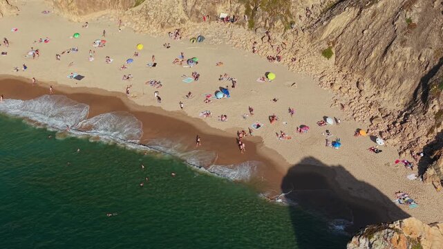 Praia da Ursa beach, Portugal, washed by waters of Atlantic Ocean. This is one of most beautiful and wild beaches. People enjoying sea, dramatic rock formations, and breathtaking coastal views.	