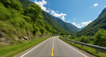 Fototapeta premium Road winding through lush green valley with mountains and blue sky perspective view for travel concept
