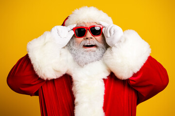 Cheerful Santa Claus wearing sunglass on a vibrant yellow background, spreading holiday joy with a modern and trendy twist
