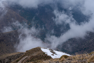 Foggy autumn mountain landscape with colorful forest in valley