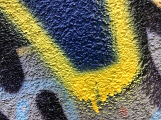 Blue and yellow street-art paint graffiti close-up rough texture wallpaper background