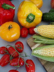 Top View of Fresh Corn and Tomatoes with Colorful Vegetables on Table