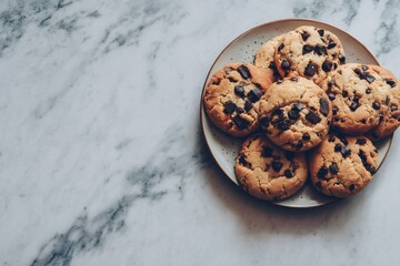 Chocolate chip cookies freshly baked on a ceramic plate, resting on a white marble countertop from an overhead view