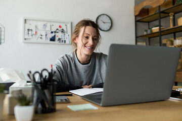 Young woman finding solace at home while working on her laptop during tough times