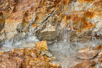 Close-up of mineral water trickling over mountain rocks