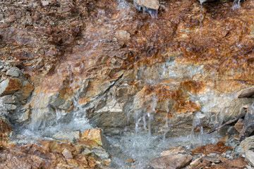 Close-up of mineral water trickling over mountain rocks