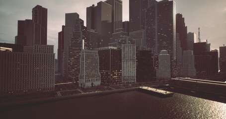 Fototapeta premium Twilight envelops the urban skyline, highlighting tall buildings reflecting on the river. The cityscape shows a mix of modern architecture against a dimming sky.