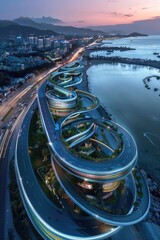 Elevated coastal highway spirals around a city, illuminated at dusk, with mountains and ocean in the background