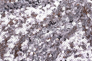 Close-up of shimmering metallic, spangle fabric with sequins creating a sparkling texture, perfect for fashion, textiles, and luxury design backgrounds.
