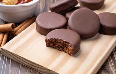 Brazilian Pao de Mel or chocolate covered honey cookies over a wooden table
