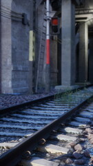 Fototapeta premium An old railway track stretches ahead, with a red light signaling at the end.