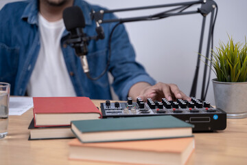 Close-up of young man recording a podcast with microphone and headphones, modern content creation and broadcasting concept.