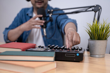 Close-up of young man recording a podcast with microphone and headphones, modern content creation and broadcasting concept.