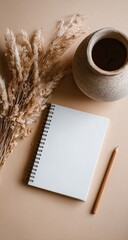 Beige flat lay with notebook, dried reeds, and vase