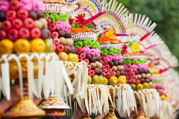 Procession of beautiful Balinese women in traditional costumes - sarong, carry offering on heads for Hindu ceremony. Arts festival, culture of Bali island and Indonesia people, Asian travel background