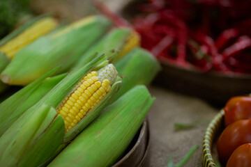 Vibrant corn on the cob displayed at a busy market, showcasing the diversity of fresh natural produce