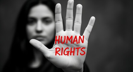 A woman holds up her hand with the words human rights written in red, symbolizing the importance of human rights and advocacy