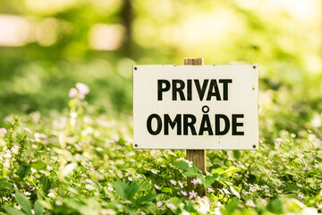 Private property sign in forest clearing.