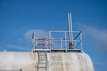 Industrial storage tank with valves and gauges.