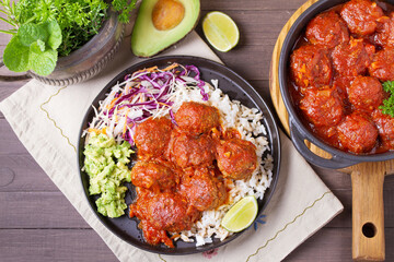 Colorful and appetizing plate of homemade meatballs served with with rice, avocado and creamy coleslaw. High angle view