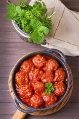 Colorful and appetizing plate of homemade meatballs served in black bowl. High angle view