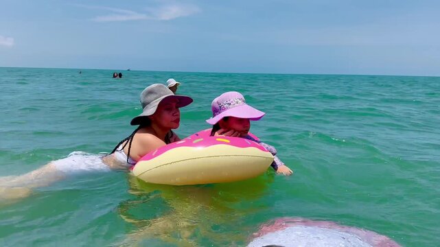 Colombian family swimming in calm sea of Cove&ntilde;as with grandfather, uncle, mother and children